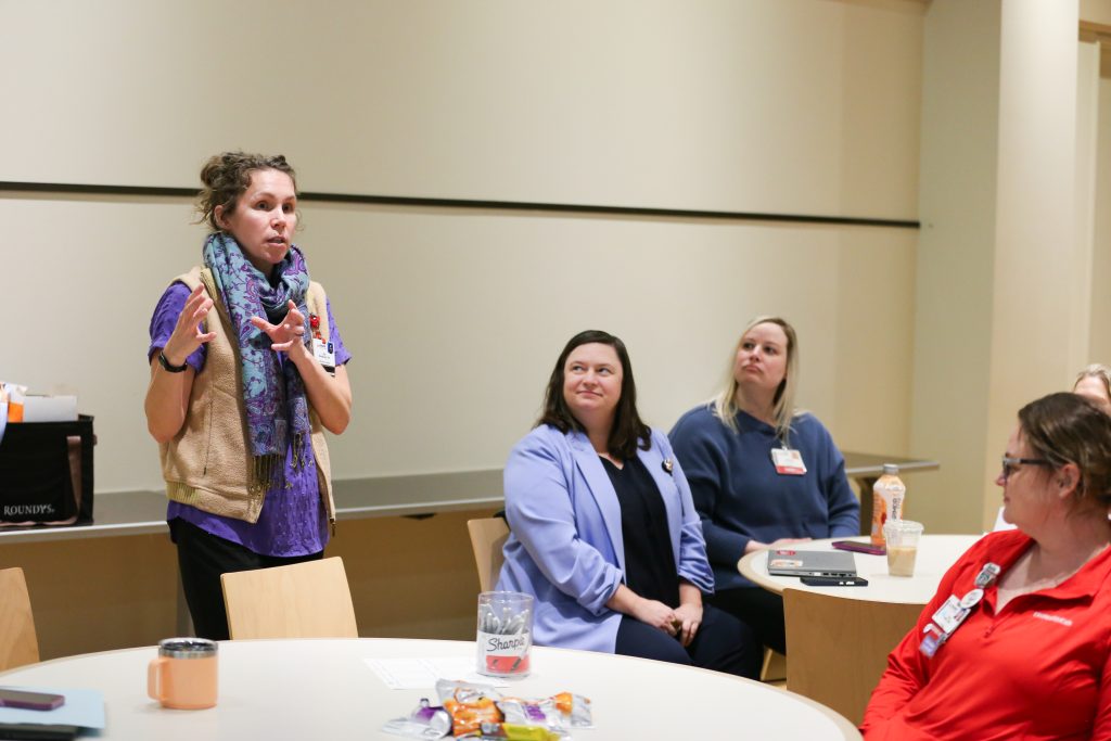 Dr. Kitty Montgomery (standing) presenting to a room of individuals.